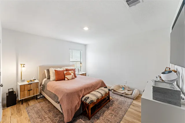 a bedroom with a bed and wooden floor
