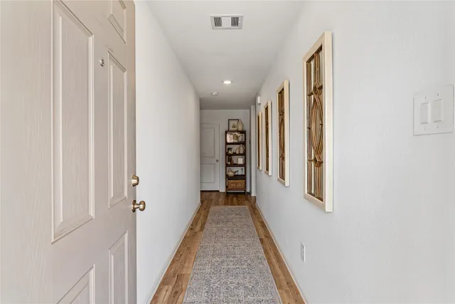 a view of a hallway with wooden floor and windows