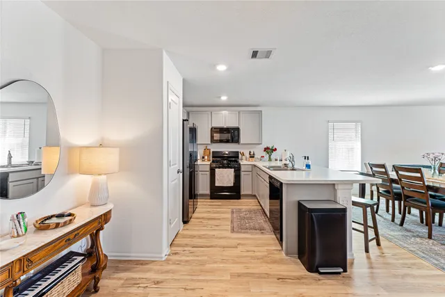 a large kitchen with cabinets and wooden floor