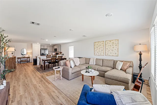 a living room with furniture and a wooden floor