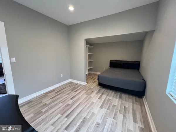 a bedroom with a bed and a wooden floor