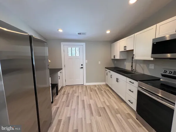 a large kitchen with a sink and stainless steel appliances