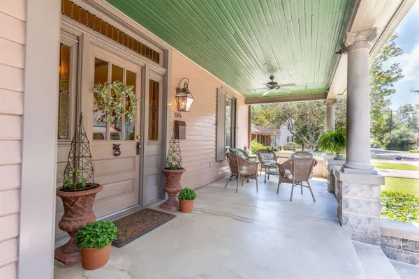 a view of a porch with chairs and potted plants