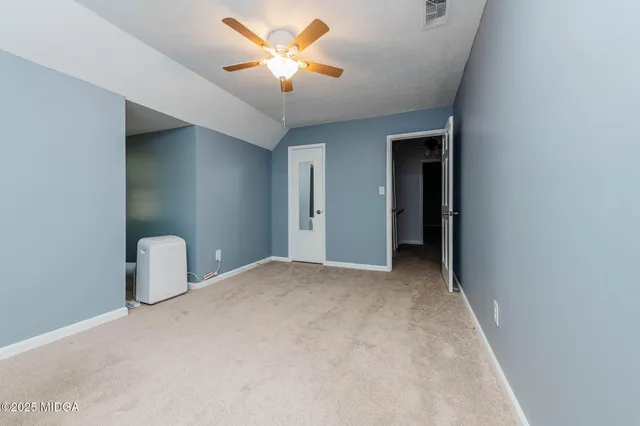 an empty room with a ceiling fan and a window