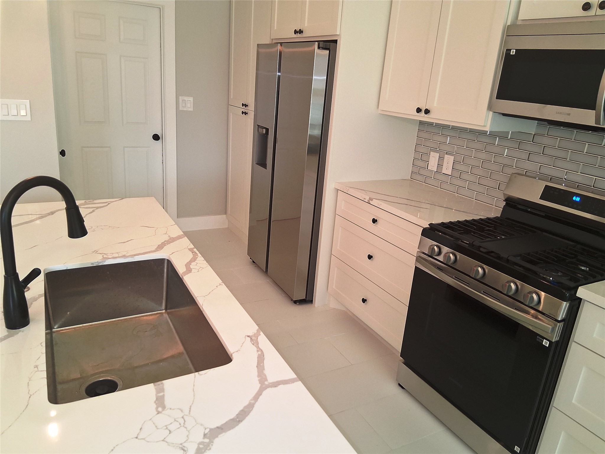 9001 Cheer Street Houston, TX 77063 - Photo 6 of 29 a kitchen with white cabinets and appliances