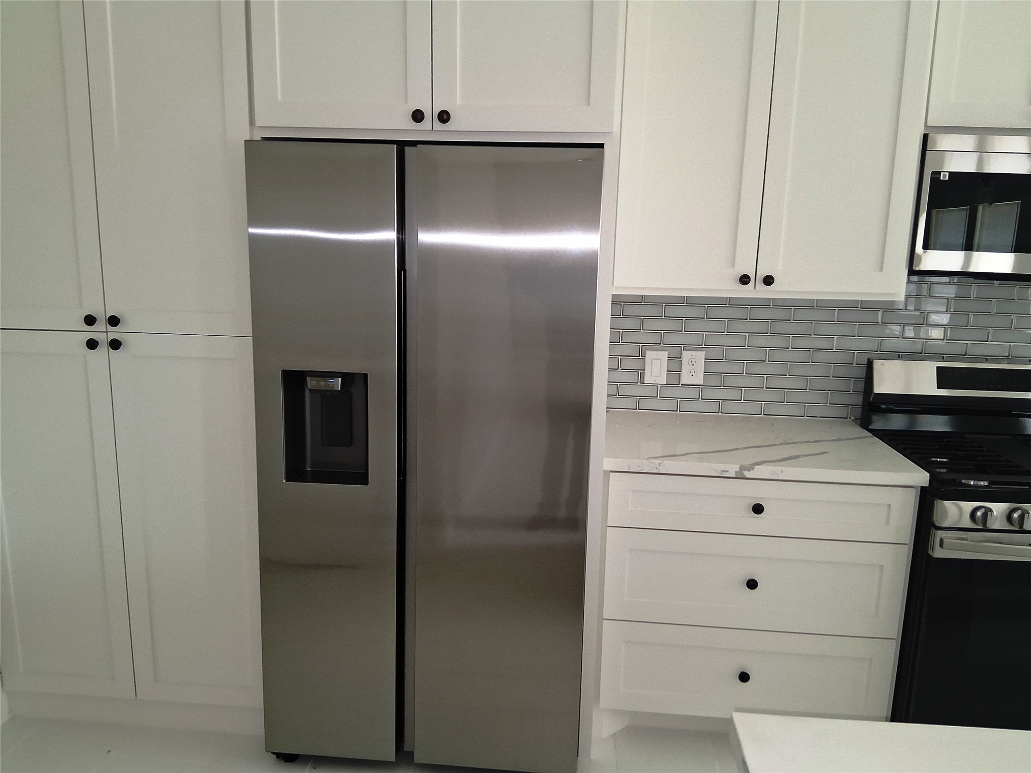 9001 Cheer Street Houston, TX 77063 - Photo 8 of 29 a kitchen with white cabinets and stainless steel appliances