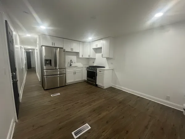 a kitchen with a refrigerator stove and white cabinets