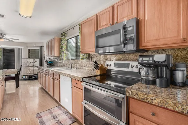 a kitchen with kitchen island granite countertop a sink a stove and cabinets