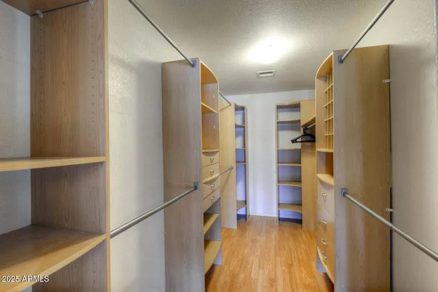 a view of walk in closet with clothes and shoes