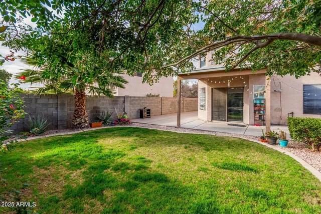 a view of a house with backyard and a tree