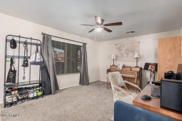 a view of a workspace with furniture and a window