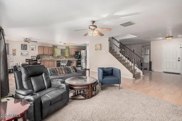 a living room with furniture and a wooden floor