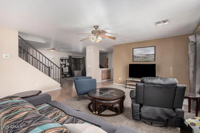 a living room with furniture a chandelier and a flat screen tv