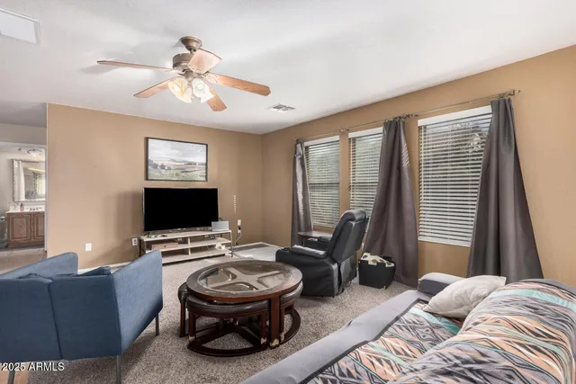a living room with furniture a flat screen tv and a window