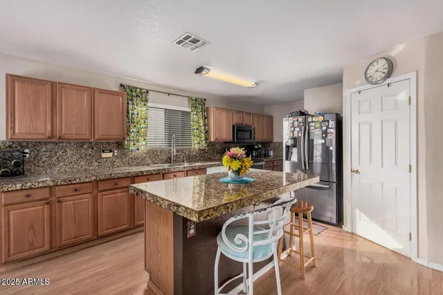 a kitchen with stainless steel appliances granite countertop a sink stove and refrigerator