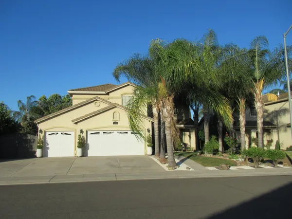 a view of a white apartments with palm trees
