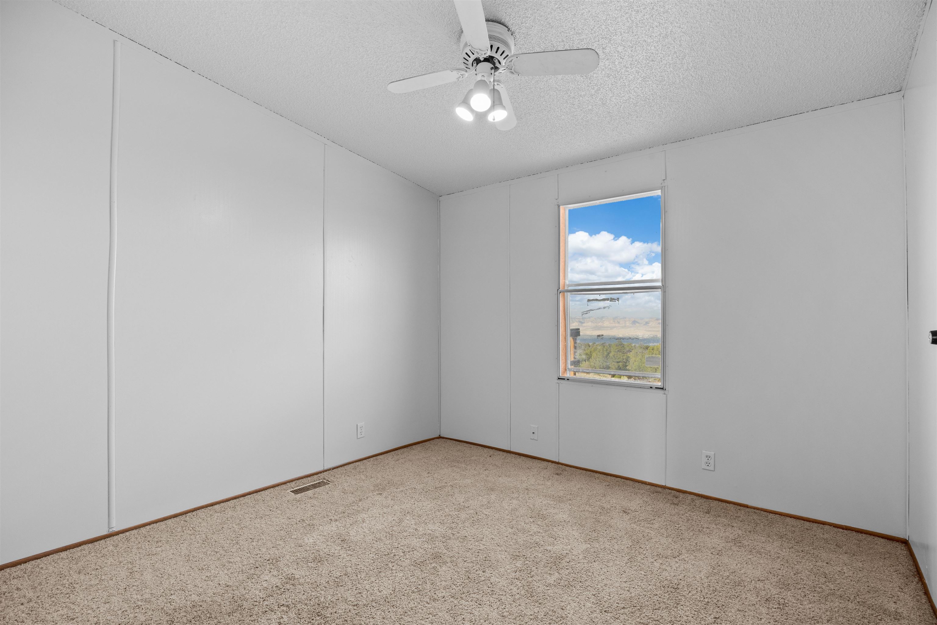 21431 Little Park Road Grand Junction, CO 81507 - Photo 21 of 40 an empty room with a window and a fan