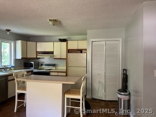 202 Crane Hollow Road Bethlehem, CT 06751 - Photo 11 of 36 a kitchen with stainless steel appliances a refrigerator and a stove top oven