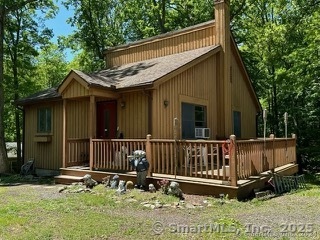 202 Crane Hollow Road Bethlehem, CT 06751 - Photo 19 of 36 a view of a house with a wooden deck and furniture