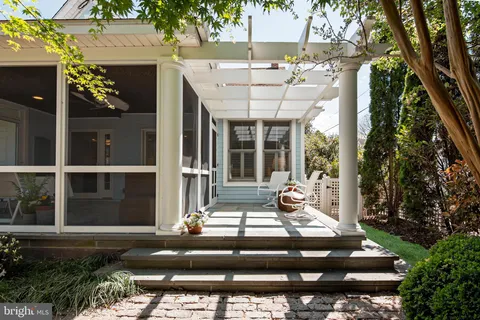a view of backyard with a table and chairs and wooden fence