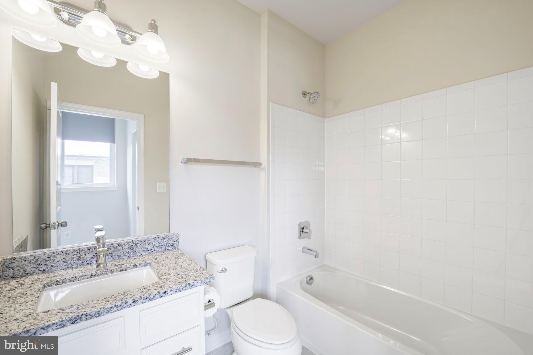 515 Riversail Lane, Unit 430 Oxon Hill, MD 20745 - Photo 34 of 54 a bathroom with a granite countertop sink a toilet and bathtub