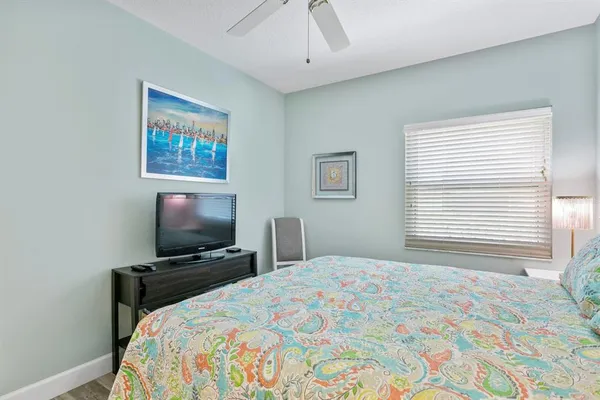 a bedroom with a bed a flat screen tv and a window