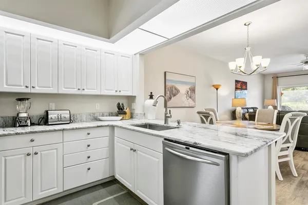 a kitchen with granite countertop white cabinets and chairs
