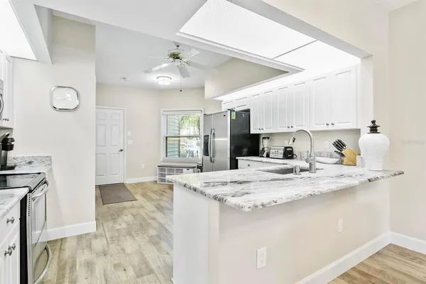 a kitchen with stainless steel appliances granite countertop a sink stove and refrigerator