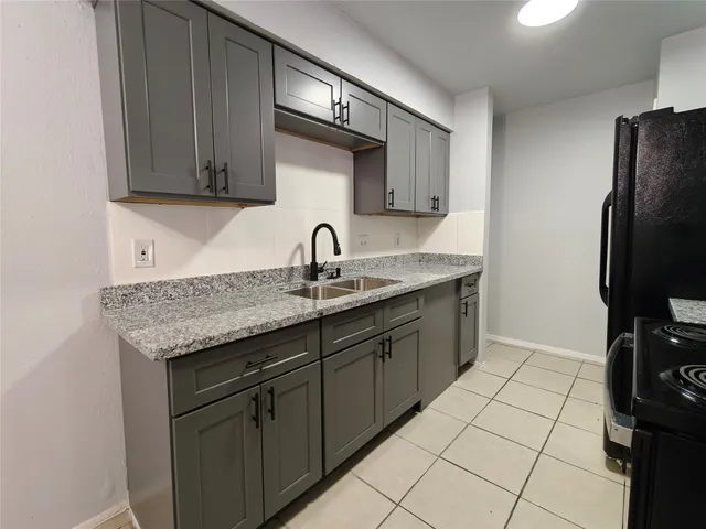 a kitchen with a refrigerator and a counter top space