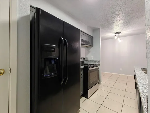 a kitchen with stainless steel appliances granite countertop a stove and a refrigerator