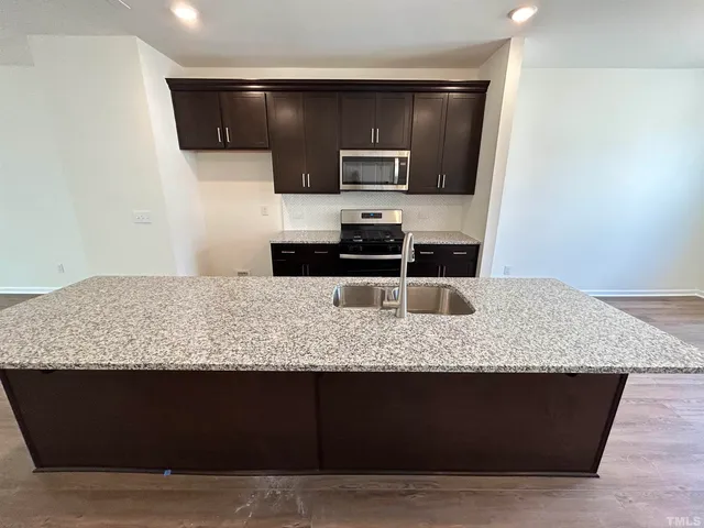 a kitchen with kitchen island granite countertop counter top space cabinets and stainless steel appliances