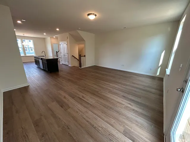a view of a big room with wooden floor and windows