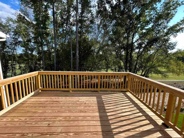 a view of balcony with wooden floor and fence