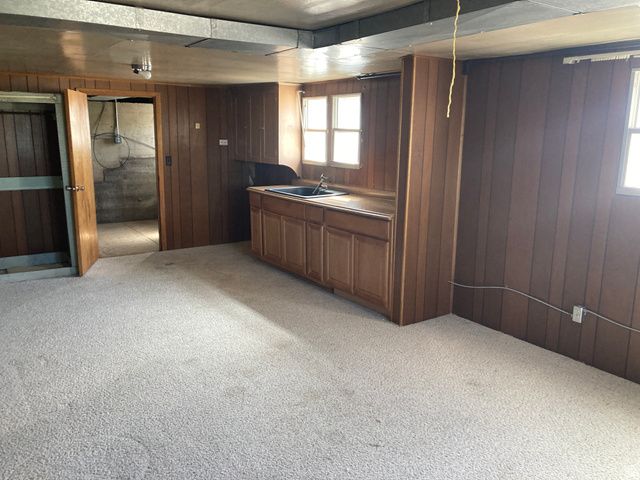 200 South 2800th Street West Ogden, UT 84404 - Photo 14 of 42 Bar area with light carpet, wooden walls, and wood finish cabinets