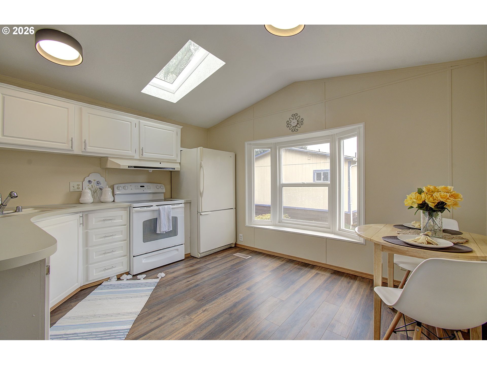 15619 Northeast Caples Road, Unit 150 Brush Prairie, WA 98606 - Photo 10 of 28 a kitchen with cabinets wooden floor and a dining table