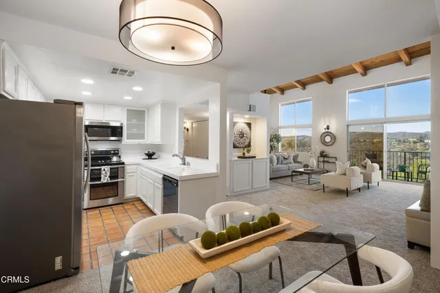a kitchen with stainless steel appliances kitchen island granite countertop a sink and a refrigerator