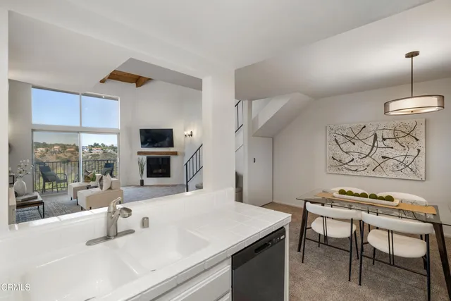 a kitchen with stainless steel appliances a stove a sink and a refrigerator with wooden floor