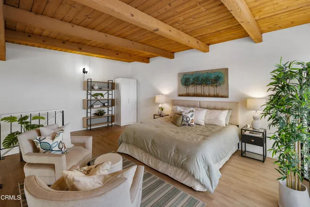 a bedroom with a bed and a potted plant