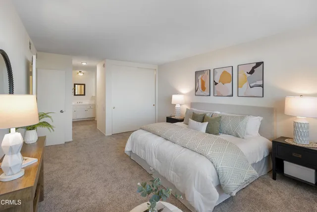 a bedroom with a bed and painting on the wall