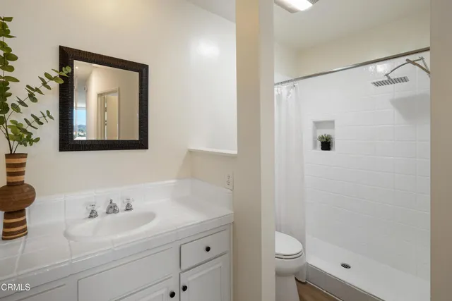 a bathroom with a double vanity sink toilet and mirror