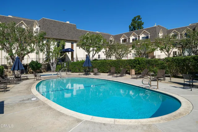 a swimming pool with outdoor seating and trees