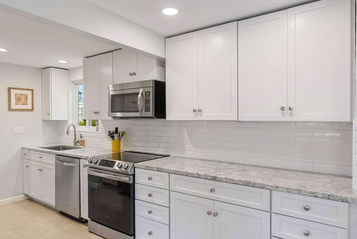 165 Bar Harbor Court Aptos, CA 95003 - Photo 8 of 37 a kitchen with granite countertop white cabinets and stainless steel appliances