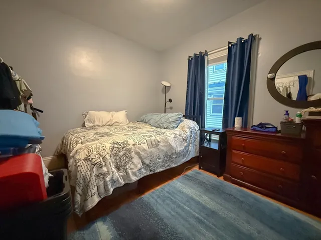 a bedroom with a bed and a mirror on dresser