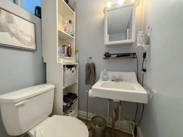 a bathroom with a toilet a sink and a mirror