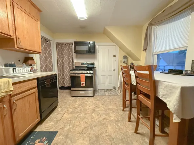 a kitchen with stainless steel appliances granite countertop a refrigerator a stove top oven a sink dishwasher and white cabinets with wooden floor