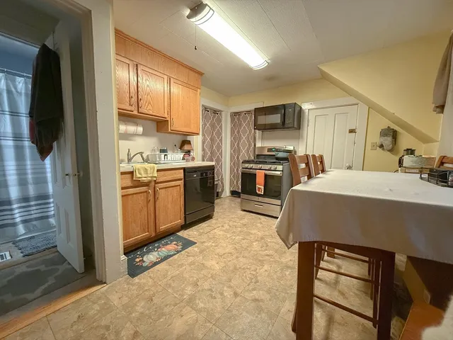 a kitchen with kitchen island a stove a sink a refrigerator and a refrigerator