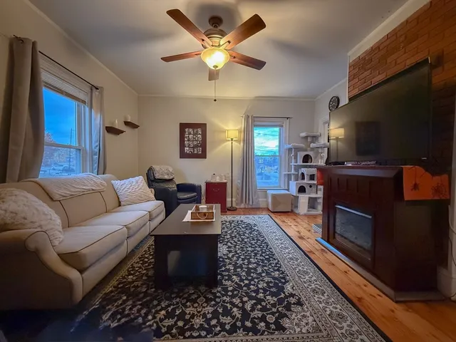 a living room with furniture a flat screen tv and a fireplace