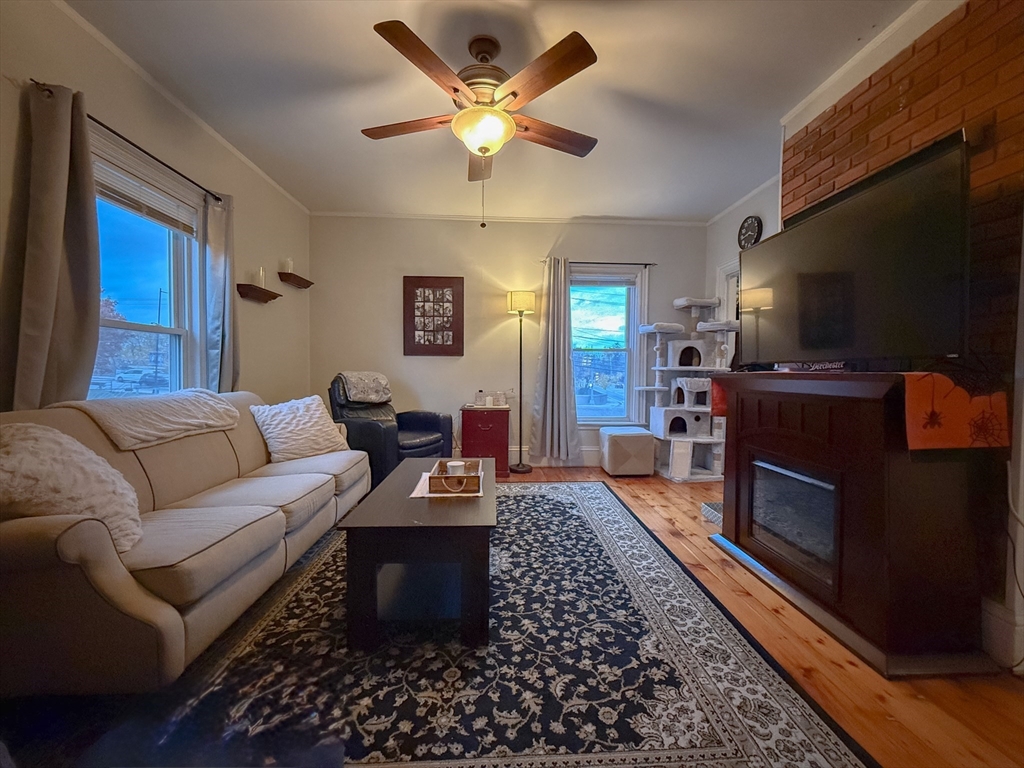 173 Elm Street, Unit 2 Braintree, MA 02184 - Photo 2 of 20 a living room with furniture a flat screen tv and a fireplace