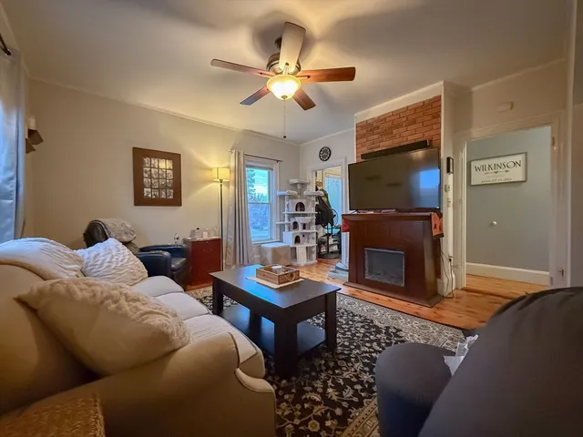 a living room with furniture a flat screen tv and a fireplace