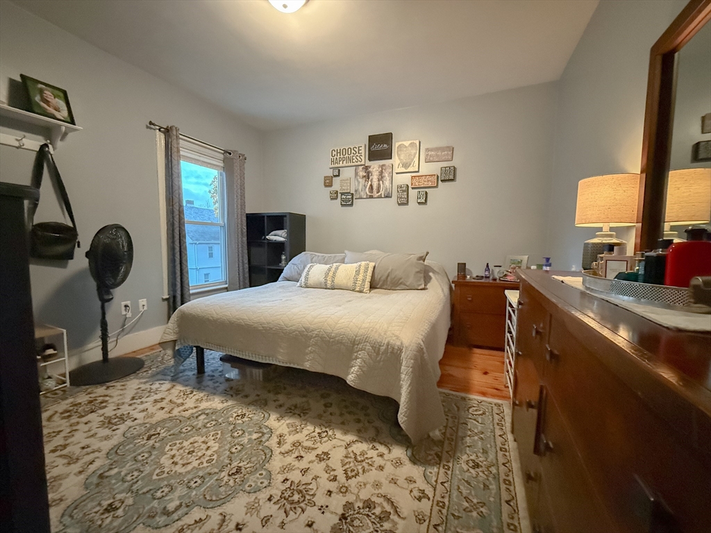 173 Elm Street, Unit 2 Braintree, MA 02184 - Photo 8 of 20 a bedroom with a bed a dresser next to a window